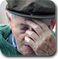 Elderly man has his eyes closed and is holding his hand to his head like he is depressed