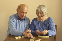 Una pareja mayor juega al dominó