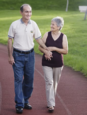Una pareja  de personas de edad avanzada caminando para hacer ejercicio