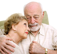 Un hombre mayor abraza a una mujer mayor que parece triste