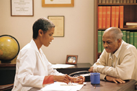 Una profesional de la salud habla con un paciente y le da información