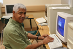 Man sits at computer desk happily, ready to work