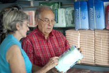 Una pareja de personas de edad avanzada seleccionando pañales desechables para adultos en una tienda