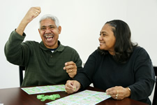 Una pareja de personas de edad avanzada divirtiéndose mientras juegan al bingo