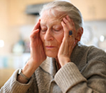 Stress woman, sitting at table with elbows and hands propping up face