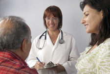 Female provider speaking to elderly patient and spouse