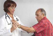 Una doctora examinando el brazo de un hombre de mayor edad