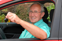 Un hombre está sentado al volante de un auto mostrando las llaves