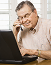 man on computer and phone