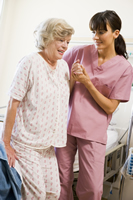 nurse helping woman stand up 