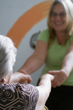 young woman helping older woman up from fall